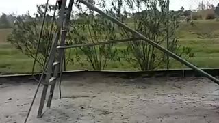 Guy in grey sweatshirt tries to stand up on a slide and ends up falling down