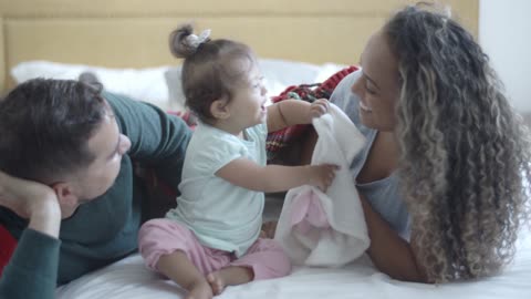 Baby can't stop laughing while playing with her mom and father