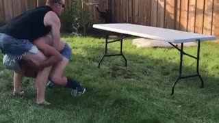 Guy lifts friend to break table