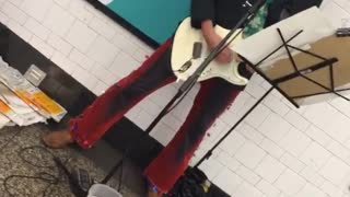 Man red hat plays guitar subway platform