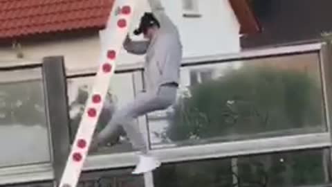 Guy hanging off railway sign