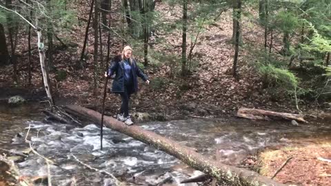 My wife crossing a log