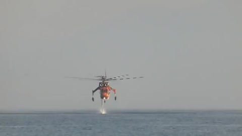 A fire helicopter take water from sea