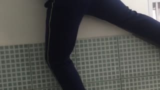 Blue shirt girl tries to climb over stair rail and falls down