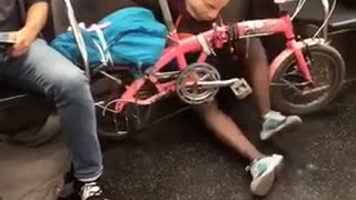 Woman with mask and pink bike pretending to ride on floor