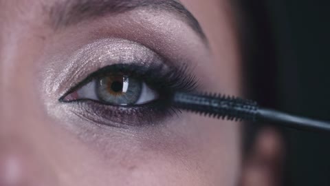 a-woman-applying-mascara-to-thickens-and-enhanced-her-eye-lashes