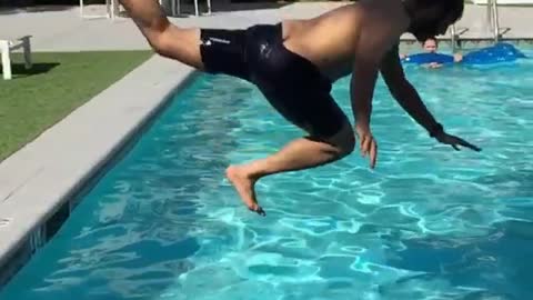 Black shorts man bellyflop pool
