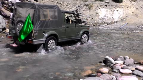 Cyclist crosses raging stream in road with ease