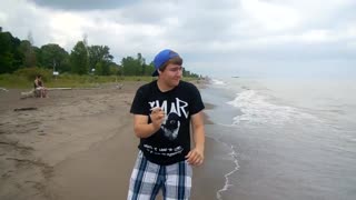 Man throws money into water at the beach