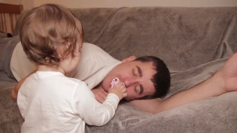 A_Cute_Baby_Gives_Dad_a_Pacifier_While_he_Sleeps