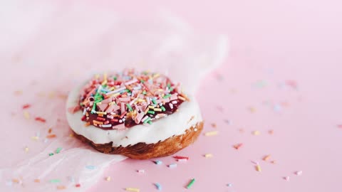 sprinkles-being-poured-on-a-donut