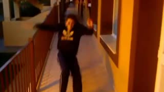 Guy in black slips and slides down hallway