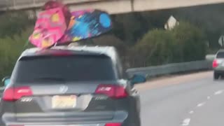 Blue and pink boogie boards on roof of car