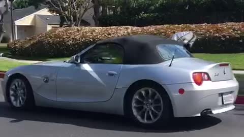 Guy bmw z4 coupe convertible driving with surfboard out of window