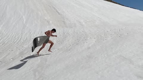 Gliding Down Snowy Slope Into Mountain Water