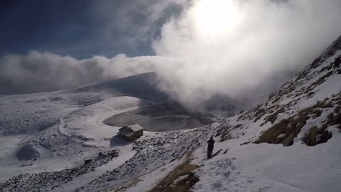 Stunning fog rolls over lake atop mountain peak
