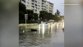 Cars face flooded Marseille street after heavy rain