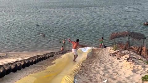 Man Surfs Down Waterslide and Somersaults Into