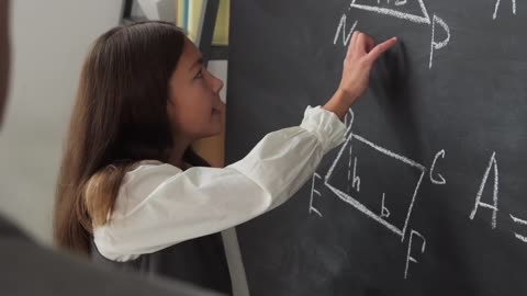 Girl Clearing her Math Doubt on Backboard