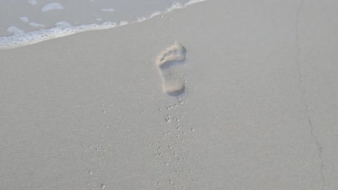 Sea Waves Running Over Foot Steps of a Person