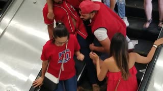 Two guys trying to get friend down elevator passed out red shirts capitals new york