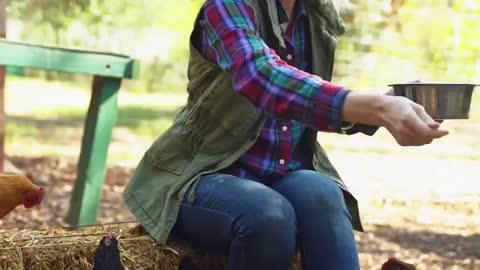 A women feeding chickens..