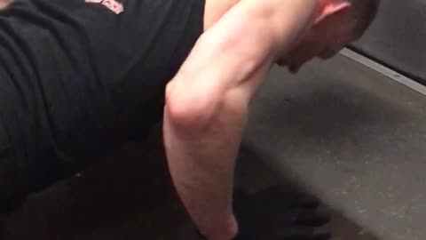 Tank top guy does pushups on the floor of subway