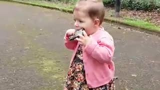 One-year-old girl preciously plays the harmonica