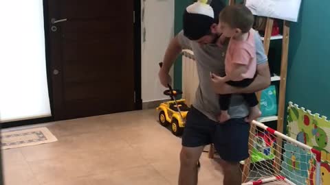 Dad performs golf trick shot challenge while holding his son