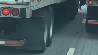 Guy Riding on Side of 18-Wheeler Holding Mirror