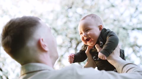 cute baby playing with is father