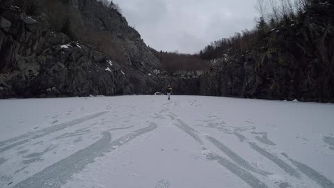 Guy Falls on Slippery Surface While Attempting to Slide on Frozen Lake