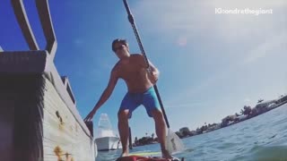 Blue shorts guy tries to get on pier falls into water paddle board