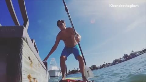 Blue shorts guy tries to get on pier falls into water paddle board