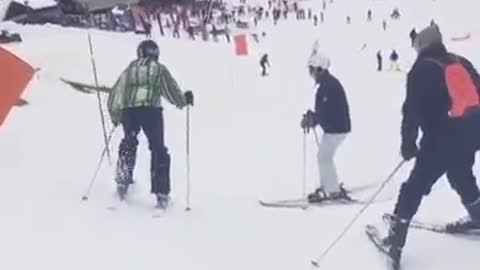 Green jacket ski crowd trip skis off