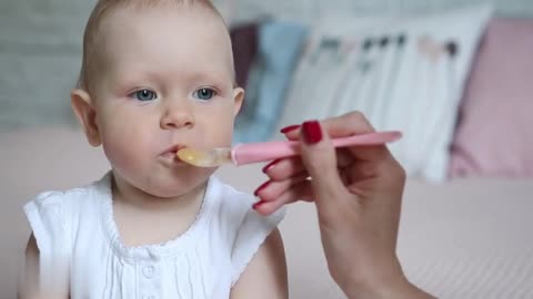 baby eats food her mom"s hand