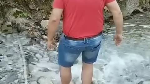 Man funny fall while crossing the river