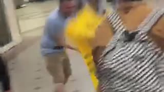 Two guys fighting with wet floor cones subway train station