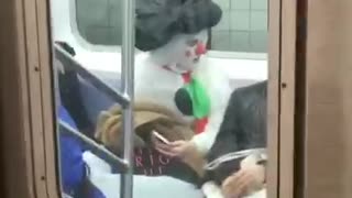 Woman with face paint, dressed in snowman suit on subway train