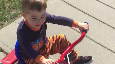My grand son riding tricycle around my neighbourhood