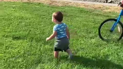 Big brother knocks over toddler while riding his bike