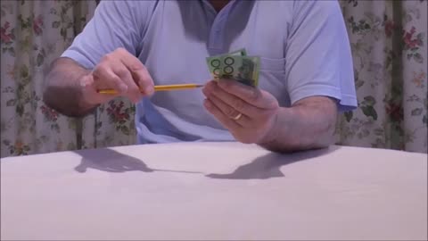 A Pencil Visibly Passes Through An Undamaged Banknote