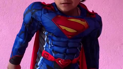 Little kid trying to fly like a Superman in Superman dress