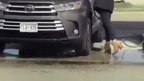 Woman washing a car at the wrong place