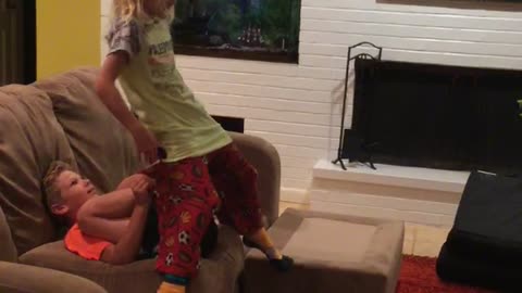 Little boy orange shirt launches little girl green shirt with legs
