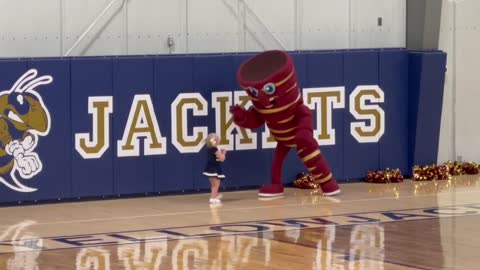 Little cheerleader dances with other team's mascot