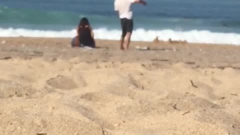 Guy gently dances by himself at the beach
