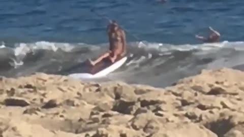 Woman falls off board with paddle board