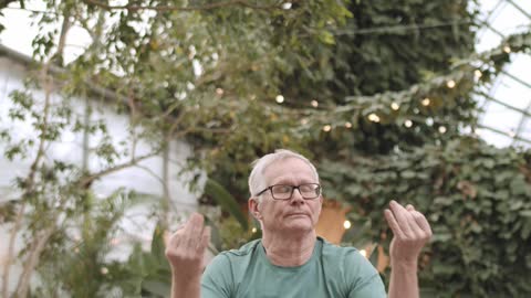 Man Doing Yoga in a Botanical Garden