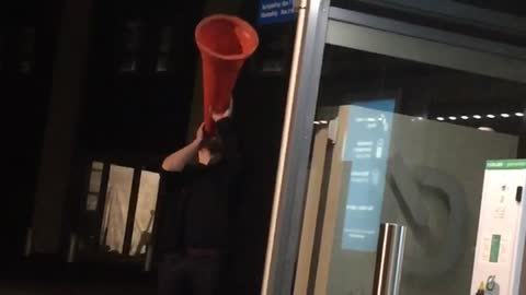 Guy making weird noises with traffic cone
